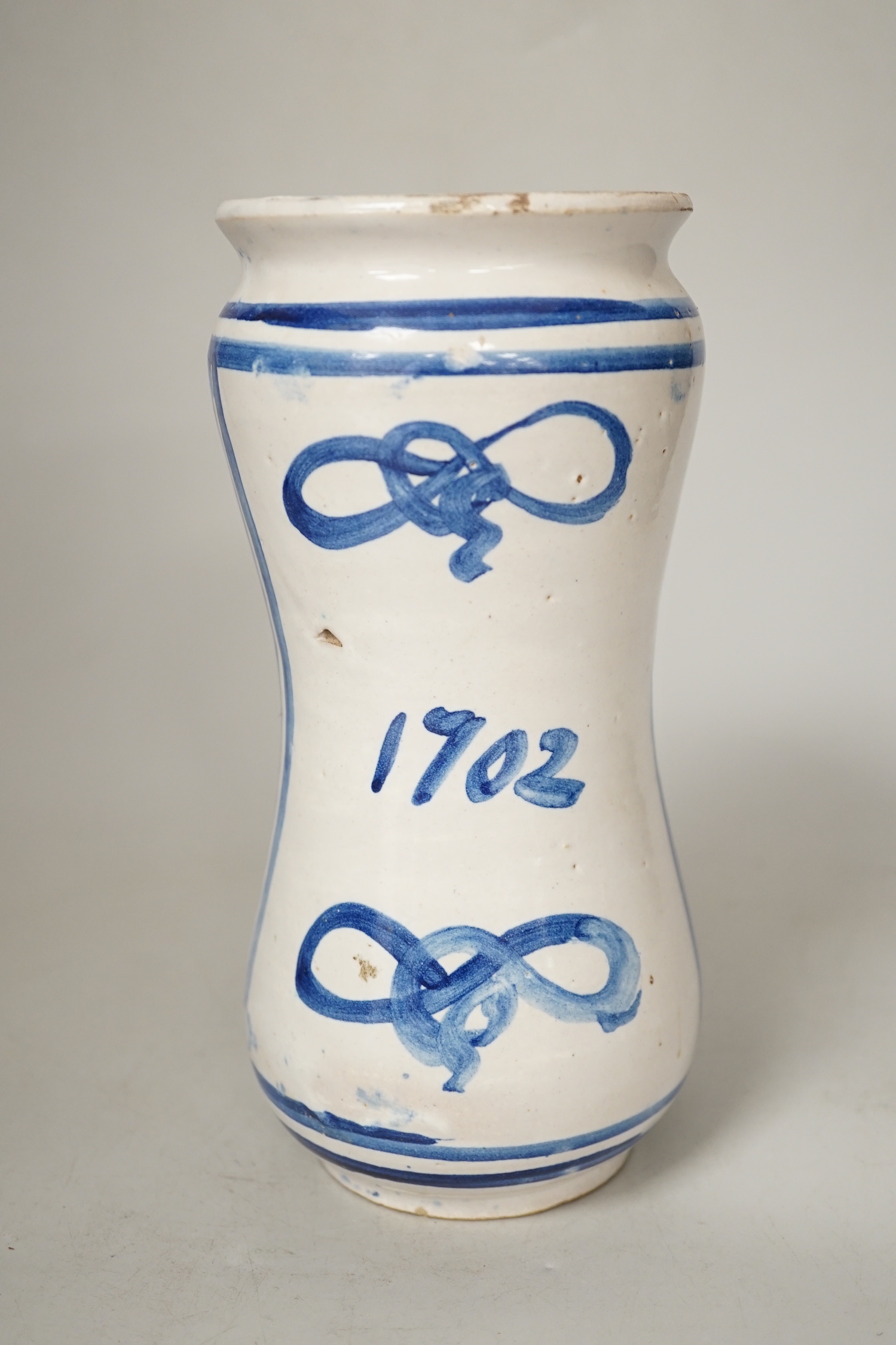 An Italian maiolica albarello, inscribed 1702, 20.5cm high